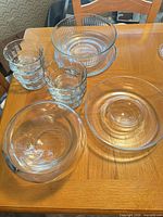 Overhead view of all clear glass pieces: six cereal bowls, ribbed bowl, chip bowl and platter