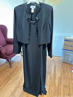 Jacket over dress on hanger showing full length and color