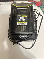 Kobalt 80 V battery seated in quick charger, cables visible