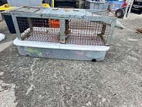 full view of galvanized animal trap on plastic bin