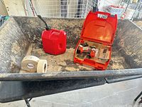 Pan interior containing gas can, drill in case, tape rolls