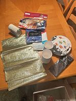 Overview showing gold tissue paper, table cover packages, cups, plates, mailbox