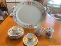 Full set on table showing platter, plates stack, creamer, sugar jar, teacups