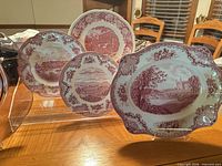 Four red and white transferware pieces on stand showing design and quantity