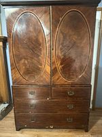 Front view of closed armoire showing veneer pattern and drawers