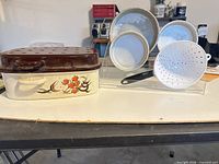 Full lot showing enamel roaster with lid, three cake pans, strainer spoon