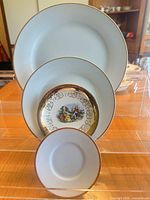 Front view showing nested rim soup plate, dessert bowl with vignette, and saucer