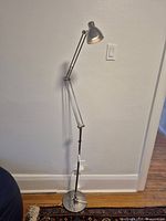 Full view of floor lamp standing against wall
