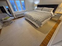 Full view of rug under bed showing geometric pattern and overall size