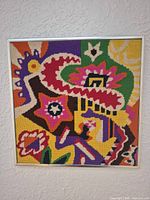 Full view of framed square abstract needlepoint