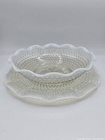 bowl nested on plate, showing scalloped opalescent rims and hobnail texture