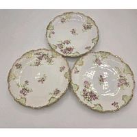 Three Limoges plates showing fronts with floral design and gilt edges
