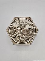 Top view showing entire hexagonal lid with duck relief scene