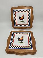 front view two wooden rooster tile trivets