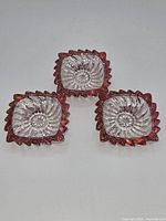 Top view of three matching square ruby flash ashtrays