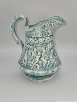 Left-side view showing relief scene and spout profile