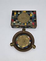 Top view of cigarette box and ashtray showing Aztec calendar medallions and stone mosaic inlay