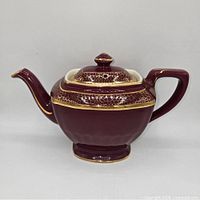 Right side view showing maroon glaze, gold crackle band, pedestal base