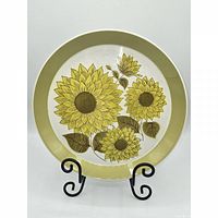 Front view of first plate showing sunflower pattern and green rim