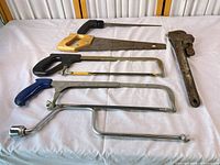 All seven hand tools laid out on white cloth