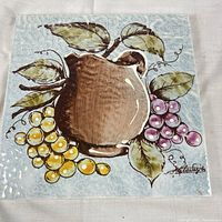 Full view of hand-painted ceramic tile front showing fruit design