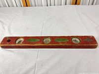 Full view of red wooden level front side with four vial openings