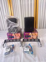 Two black bookshelf speakers on Pyle amplifier boxes with brackets and cables