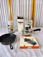 Group shot showing all items: skillet, saucepan with lid, bottle warmer, Hamilton Beach box, Yuban box with cords, Wohnhilfe box