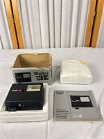 Flash unit in styrofoam next to box, manual, insert