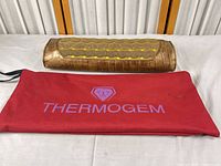 Pillow with red Thermogem bag on table