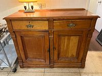 Front view of solid wood sideboard showing drawers, doors, carved trim