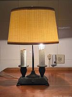 Full view of lit table lamp with shade showing overall form