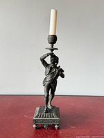 Full view of candlestick with candle on red surface