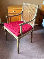 Three-quarter view of chair showing frame, cane back, seat cushion