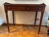 full front view of mahogany console table showing both drawers and legs
