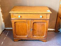 Front view showing drawer, doors, knobs, missing back panel