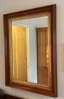 Full view of rectangular mirror with wood and gilt frame