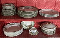 Multiple stacks of plates, serving bowl, teacup with saucer, covered serving dish
