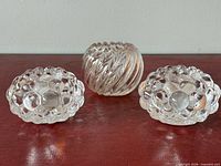 Three clear glass candleholders: two bubble-pattern Orrefors tealight holders, one twisted rib votive