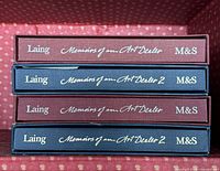 Stack of four slipcased books showing spines with titles and publisher