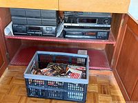 Cabinet view showing three stereo components and crate of media