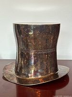 Front view of silver-plated top-hat bucket showing tarnished surface