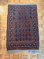 Full view of Baluch prayer rug on parquet floor
