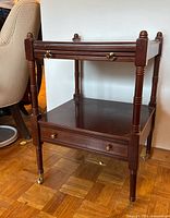Front angled view of mahogany two-tier cart with slide tray closed and drawer closed