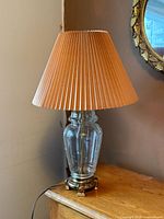 Full view of brass and glass table lamp with shade