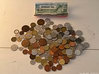Pile of assorted coins with stack of Canadian Tire 5-cent notes
