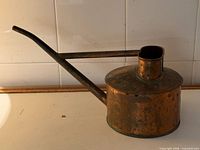 Side view showing cylindrical body, long spout, missing handle