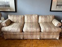 Front view of Century damask sofa showing three seat and back cushions, rolled arms, skirted base