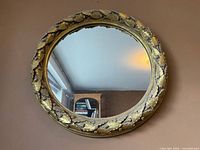 Front view showing full mirror and decorative gilt leaf border