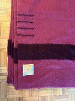 Close view showing plum wool, dark stripe, point stripes, and Made in England label